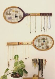 Organize your jewelry with thrifted items and hang them on the wall like home decor